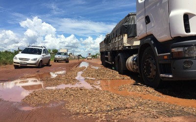 Carreta atola em cratera que foi reparada com “pedras” pela prefeitura 