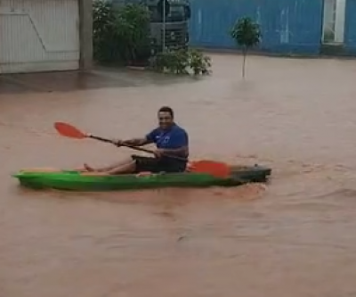 Homem usa caiaque após enchente em ruas do Parque São Carlos 