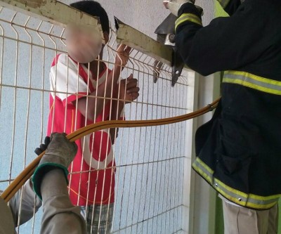 Estudante tenta pular portão de escola e acaba ficando preso à grade