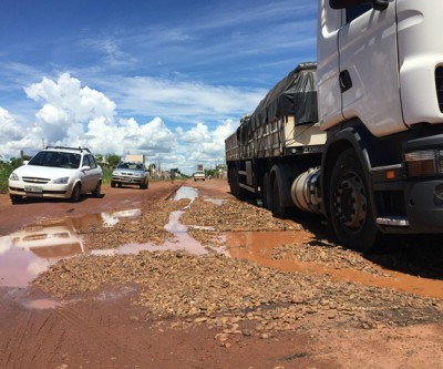 Carreta atola em cratera que foi reparada com “pedras” pela prefeitura 