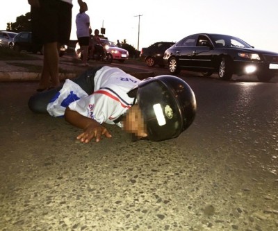 Mulher cai de moto e fica “estendida