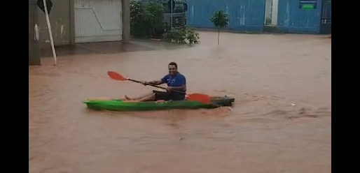 Homem usa caiaque após enchente em ruas do Parque São Carlos 